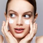 Girl applying cream for dry skin