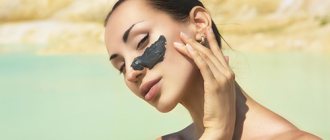 Девушка у моря с мазком чёрной глины на лице